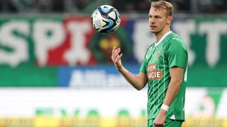 Rapid Wien-Spieler Marco Grüll jongliert einen Ball mit der rechten Hand.