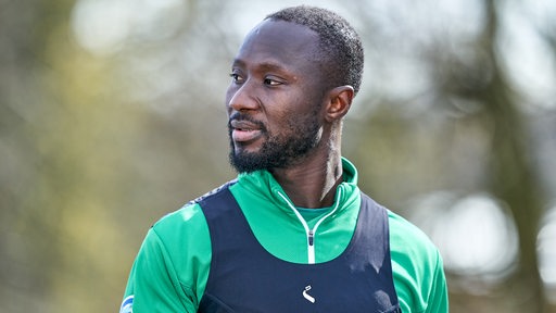 Werder-Spieler Naby Keita blickt nachdenklich zum Trainingsgelände.