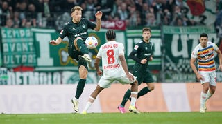 Werder-Spieler Senne Lynen spielt einen hohen Pass mit der Innenseite.