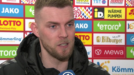 Werder-Stürmer Marvin Ducksch spricht während eines Interviews in ein ARD-Mikrofon.