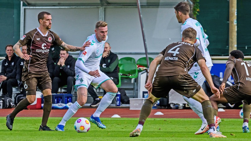 Werder-Stürmer Marvin Ducksch dribbelt mit dem Ball auf die Pauli-Abwehr zu.