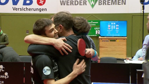 Tischtennisspieler von Werder Bremen umarmen sich nach einem gewonnenen Spiel.