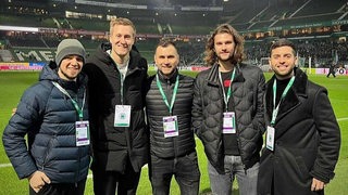 Werders Tischtennis-Profis Gerassimenko, Falck, Pletea, Aguirre und Trainer Tamas beim Gruppenbild auf dem Rasen des Weser-Stadions.