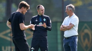 Werder-Trainer Ole Werner und Frank Baumann sprechen während einer Traingseinheit miteinander.