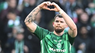 Werders Oliver Burke formt mit seinen Händen ein Herzchen.