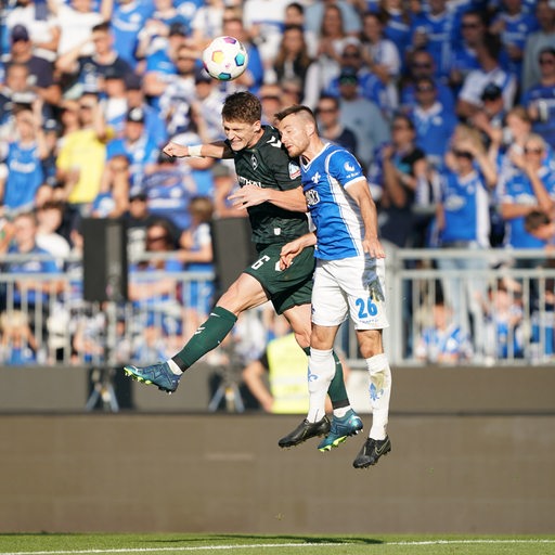 Werder-Spieler Jens Stage beim Kopfball im Duell mit seinem Gegenspieler.
