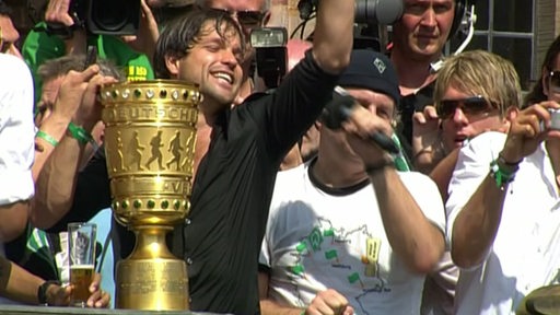 Ein Archivbild mit dem ehemaligen Werder- Profi Diego, der mt dem Pokal in seiner Hand in einer Menschenmenge jubelt.