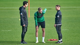 Werder-Stürmer Marvin Ducksch fasst sich im Training an den Rücken.