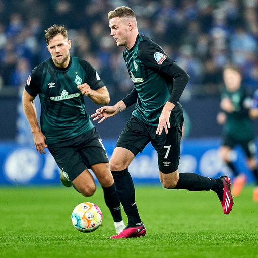 Werder-Stürmer Marvin Ducksch dribbelt mit dem Ball, während Niclas Füllkrug ihn hinterläuft.