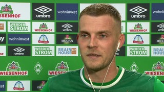 Werder-Stürmer Marvin Ducksch beim Interview nach dem Spiel vor einer Videowand.