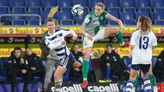 Lina Hausicke von Werder Bremen kämpft mit zwei Spielerinnen vom MSV Duisburg um den Ball.