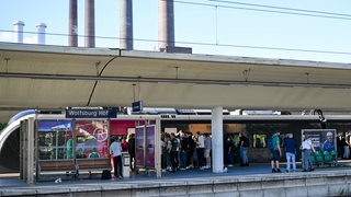 Zu sehen sind wartende Werder-Fans an einem Gleis im Wolfsburger Bahnhof.