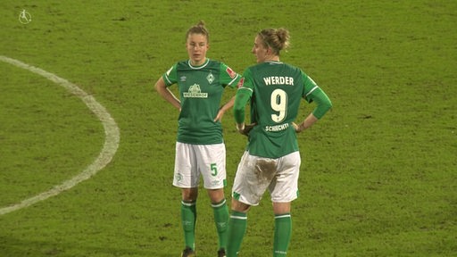 Zwei Spielerinnen der Werder-Frauen stehen bedrückt der einer Niederlage auf dem Spielfeld.