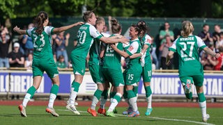 Die Spielerinnen des SV Werder Bremen bejubeln einen Treffer.