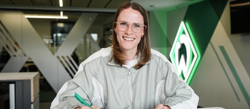 Reena Wichmann unterschreibt ihren Vertrag in der Geschäftsstelle des SV Werder Bremen