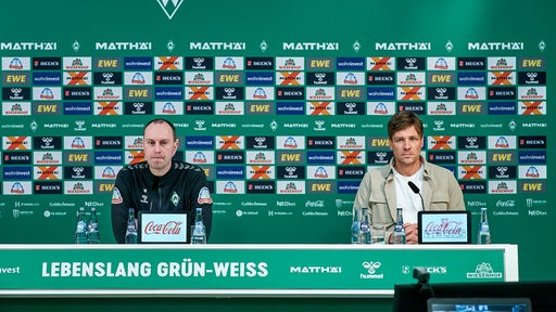 Ole Werner und Clemens Fritz sitzen bei der Pressekonferenz auf dem Podium.