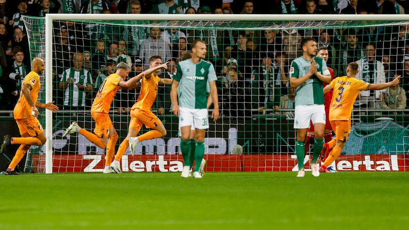 Die Hoffenheimer Spieler jubeln. Christian Groß und Milos Veljkovic schauen bedröbbelt.