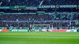 Auf einem Banner in der Ostkurve steht: "auf dem geschrieben steht: "@Werder: Neuer Versuch es besser zu machen — Nein zu Investoren in der DFL!"
