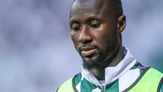 Naby Keita trägt ein Trainingsleibchen und schaut enttäuscht.