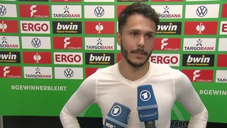 Werder-Spieler Leonardo Bittencourt vor einer Werbewand beim Interview nach dem Spiel.