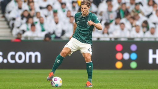 Niklas Stark hält im Werder-Trikot den Ball am Fuß.