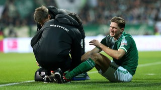 Niklas Stark sitzt auf dem Boden und wird nach der Verletzung gegen den BVB behandelt.