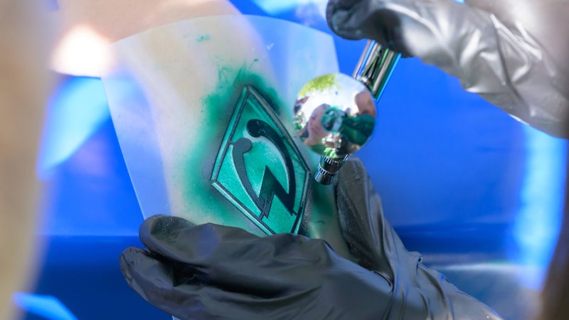Ein Fan bekommt das Werder-Logo auf den Arm gesprüht.