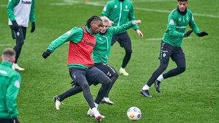 Werder-Spieler Skelly Alvero spielt im Training unter Bedrängnis einen Pass.