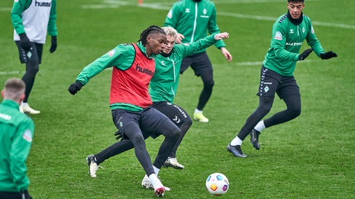 Werder-Spieler Skelly Alvero spielt im Training unter Bedrängnis einen Pass.