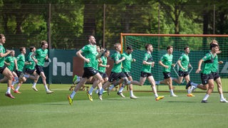 Die Werder-Spieler laufen sich im Training warm.