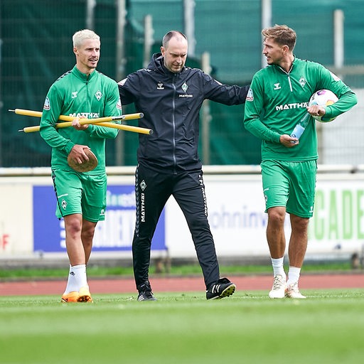 Am Rande des Werder-Trainings spricht Coach Ole Werner mit Kapitän Marco Friedl und Niklas Stark.