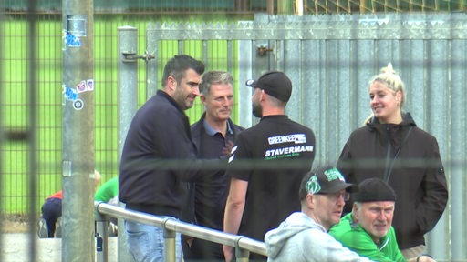 Der portugiesische Co-Trainer Richard Evans und Teammanager Carlos Godinho sprechen am Rande des Werder-Trainings auf Platz 11 mit Greenkeeper Tim Engelke.