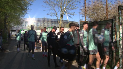 Die Werder Spieler auf dem Weg zum Trainingsplatz, im Hintergrund ist das Weser-Stadion zu sehen