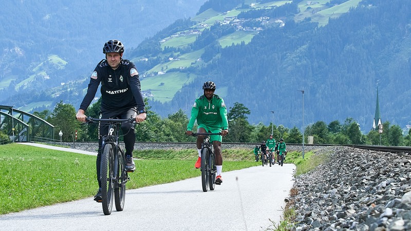 Ole Werner fährt im Zillertal auf dem Fahrrad. Hinter ihm ist ein Bergpanorama zu sehen.