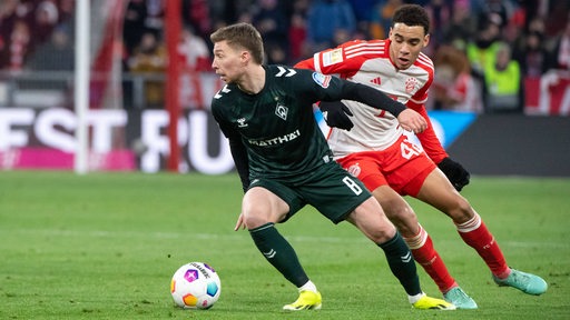 Werder-Spieler Mitchell Weiser schirmt den Ball gegen Bayern-Spieler Jamal Musiala ab.