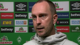 Werder-Trainer Ole Werner nach dem Frankfurt-Spiel vor einer Werbewand beim Interview.