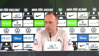 Werder-Trainer Ole Werner auf dem Podium bei der Pressekonferenz nach dem Spiel in Wolfsburg.