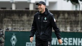 Werder-Trainer Ole Werner lacht während einer Trainingseinheit.