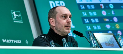 Ole Werner sitzt auf dem Podium und beantwortet Fragen auf der Pressekonferenz. 