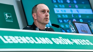 Ole Werner sitzt bei der Pressekonferenz auf dem Podium. 