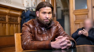 Tim Wiese sitzt im Gericht auf einem Stuhl. 