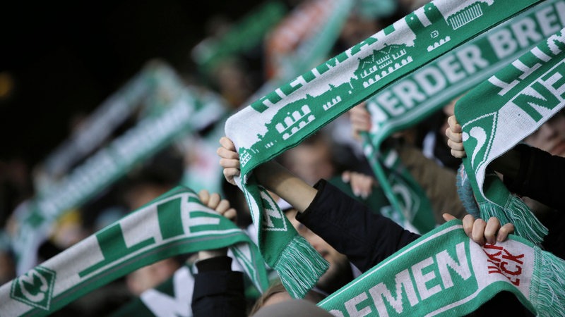 Werder-Fans halten ihre Schals in die Luft (Archivbild)
