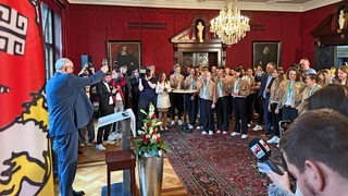 Andreas Bovenschulte prostet nach seiner Rede den Werder-Frauen beim feierlichen Empfang im Rathaus zu.