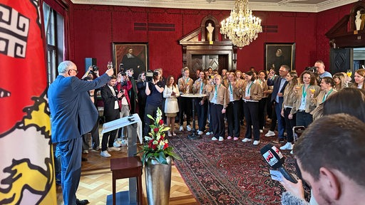 Andreas Bovenschulte prostet nach seiner Rede den Werder-Frauen beim feierlichen Empfang im Rathaus zu.