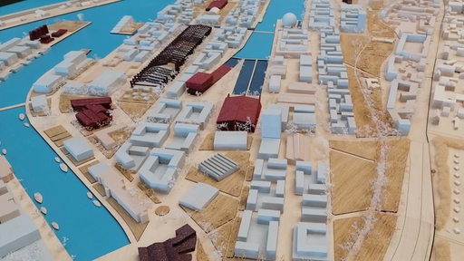 Blick auf ein Modell mit Wasserlauf, Häusern und Schiffen.