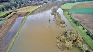 Blick auf die nach dem Hochwasser über die Ufer getretene Weser, die an Feldern vorbeifließt.