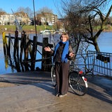 Reporterin steht mit einem Fahrrad vor der Weser.