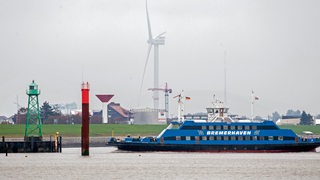 Eine Weserfähre ist bei trübem Wetter auf der Weser unterwegs.