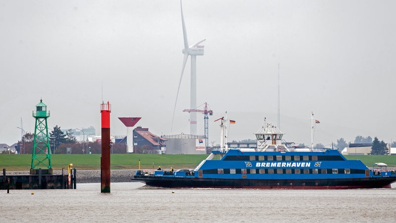 Eine Weserfähre ist bei trübem Wetter auf der Weser unterwegs.