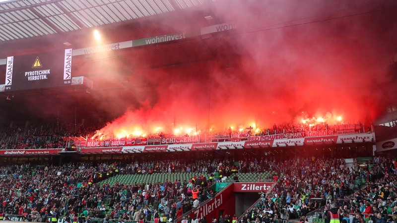 Fans des FC Bayern München zünden im Gästeblock des Weser-Stadions Pyrotechnik